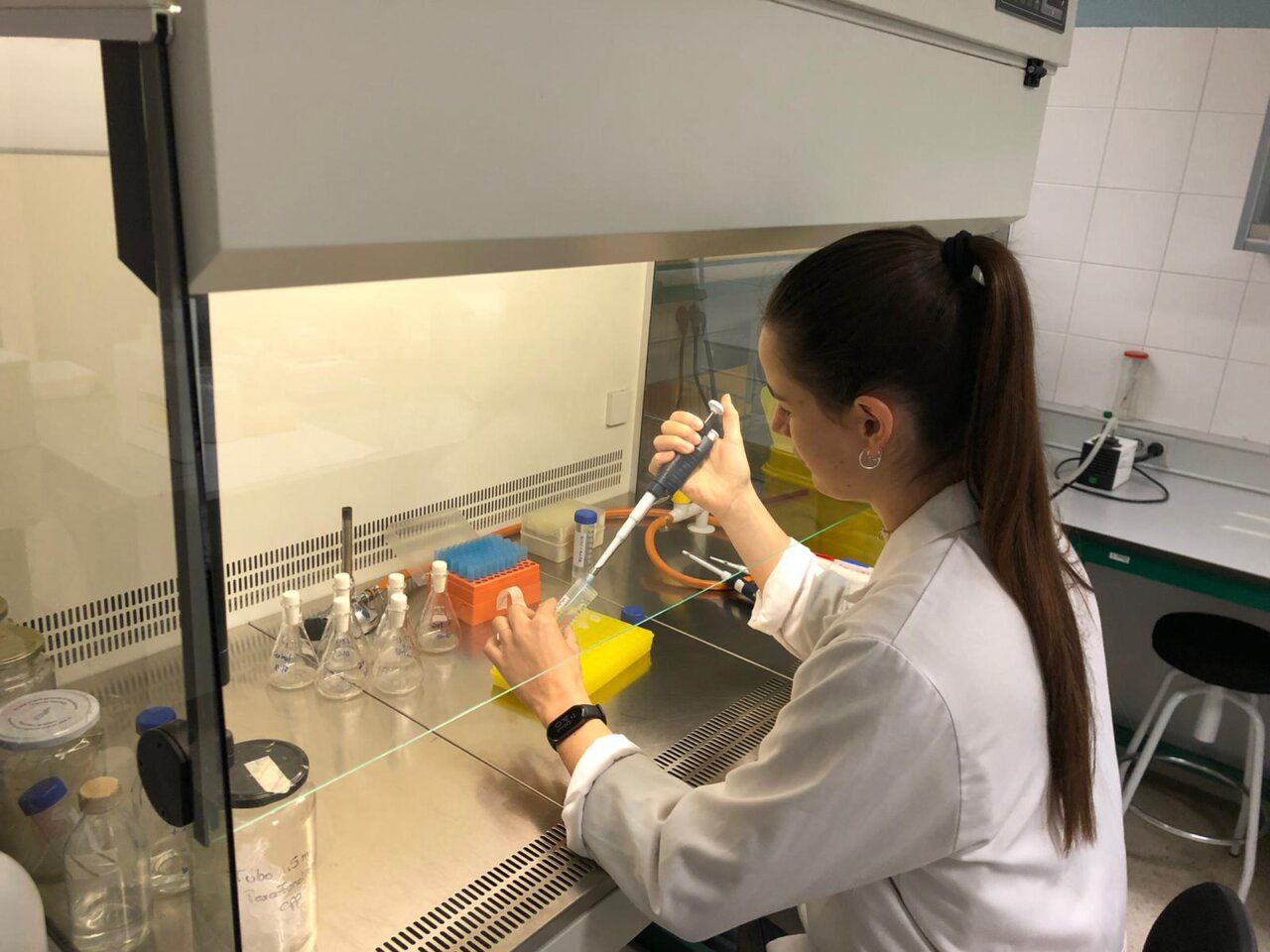 Mujer en laboratorio usando pipeta en un entorno controlado