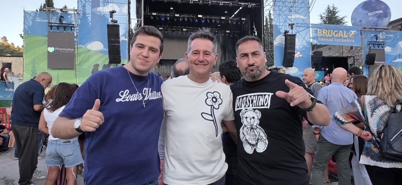 Tres amigos posando en un festival de música al aire libre
