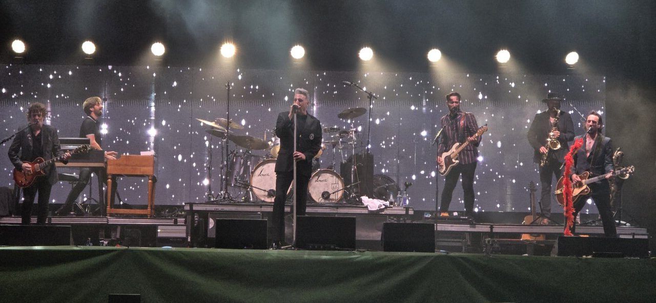 Banda en concierto con luces brillantes en el escenario