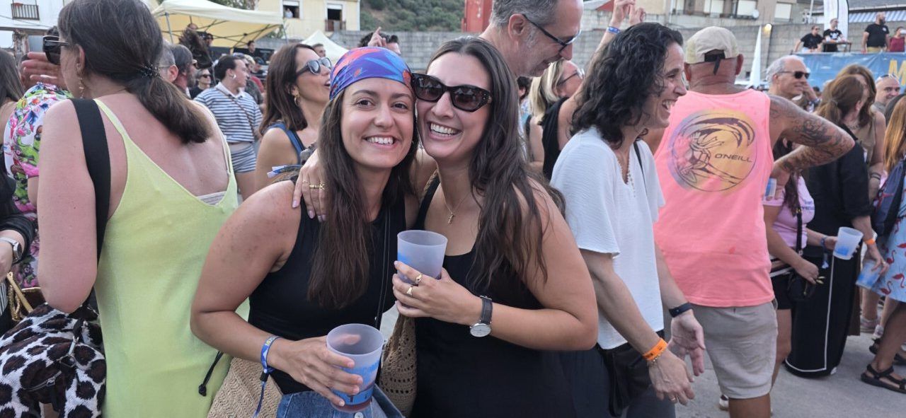Dos amigas sonrientes en un festival de música al aire libre