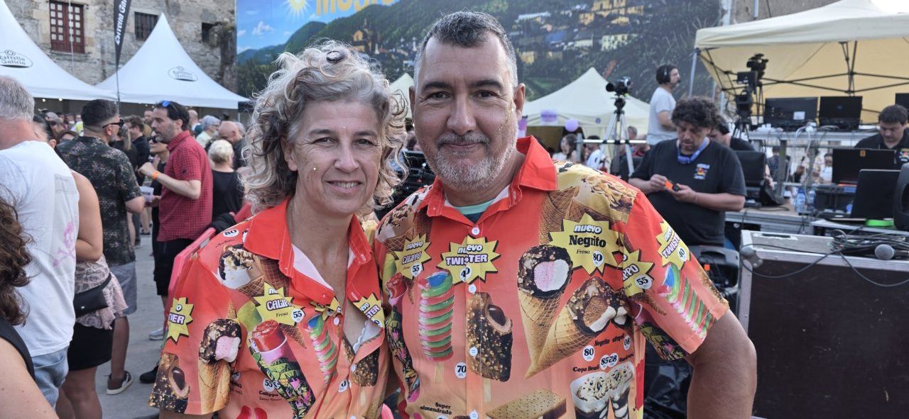 Pareja sonriendo en un evento musical con camisas coloridas