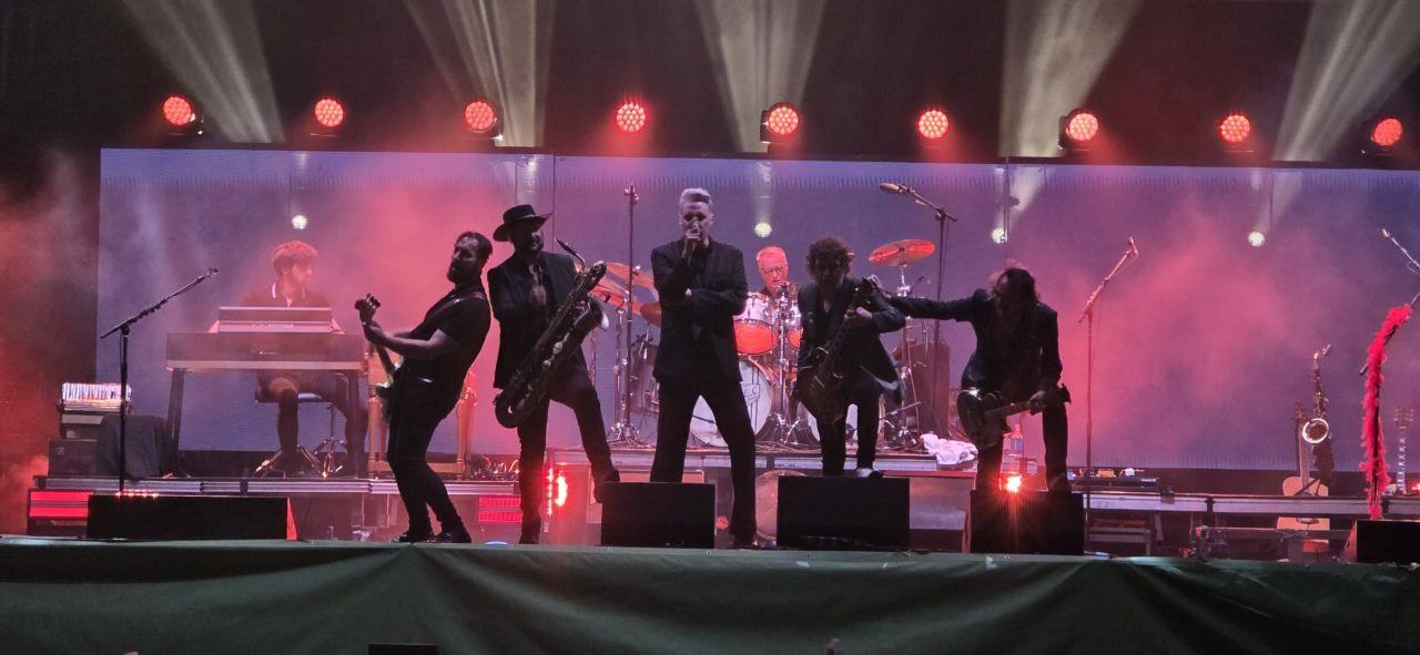 Grupo de músicos en un escenario durante un concierto en vivo