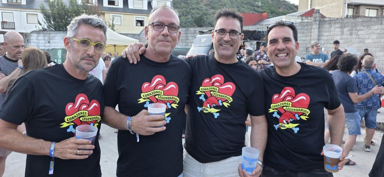Cuatro hombres en un festival con camisetas de Corazones Legendarios