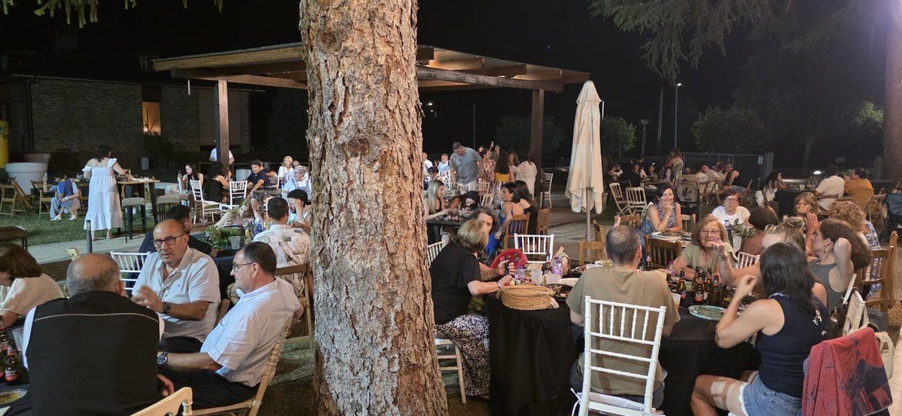 Celebración nocturna en Molinaseca con muchas personas y mesas