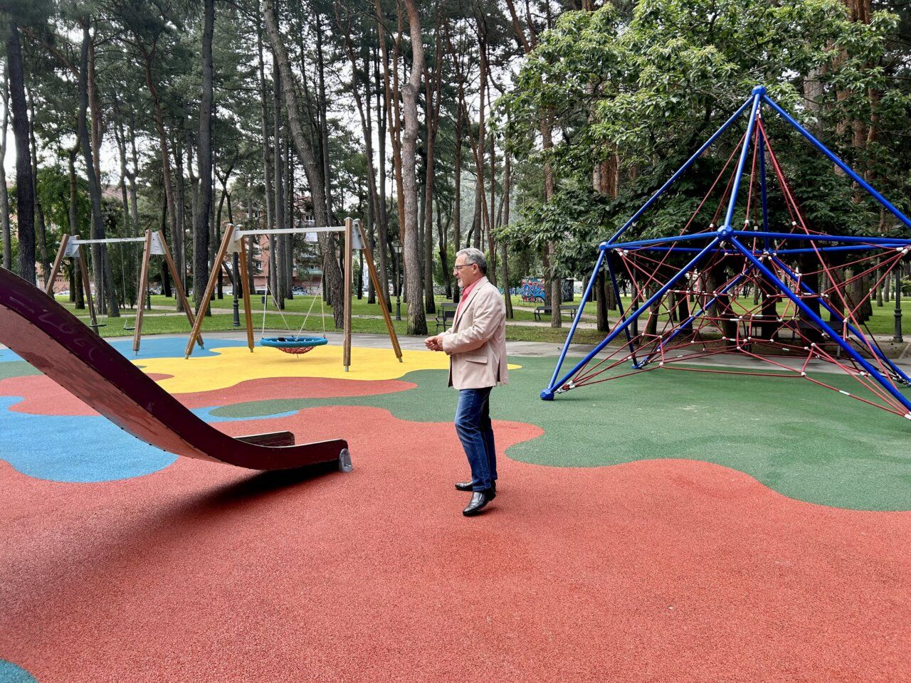 Hombre en parque infantil con suelo de caucho renovado