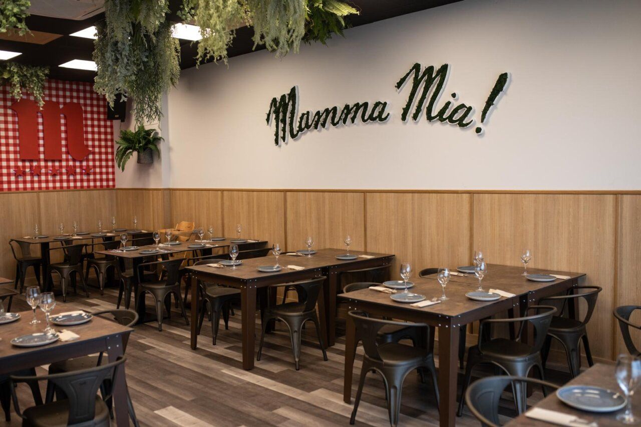 Interior de la pizzería Mamma Mia con mesas y decoración italiana