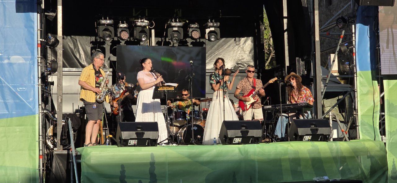 Banda tocando en un escenario al aire libre durante un evento musical