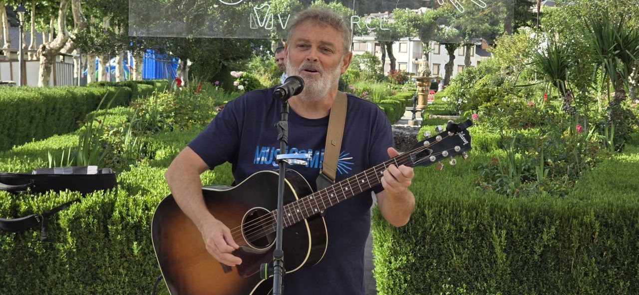 Músico tocando la guitarra en un evento al aire libre