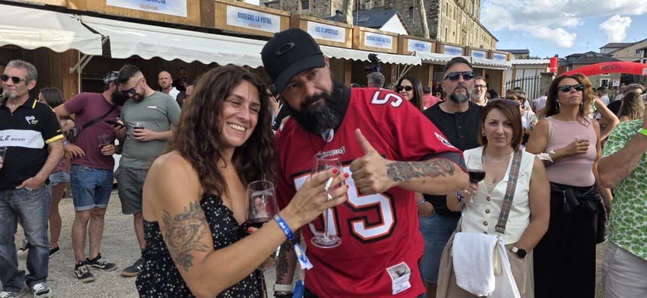 Pareja sonriente brindando en un festival al aire libre
