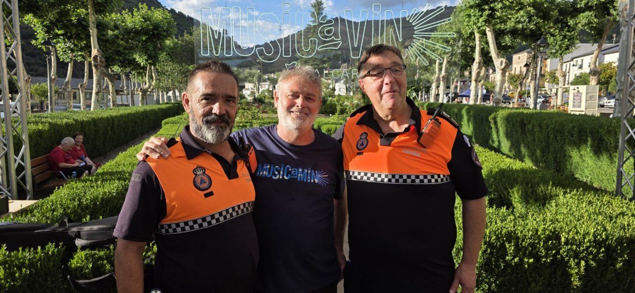 Tres hombres posando en un evento musical al aire libre