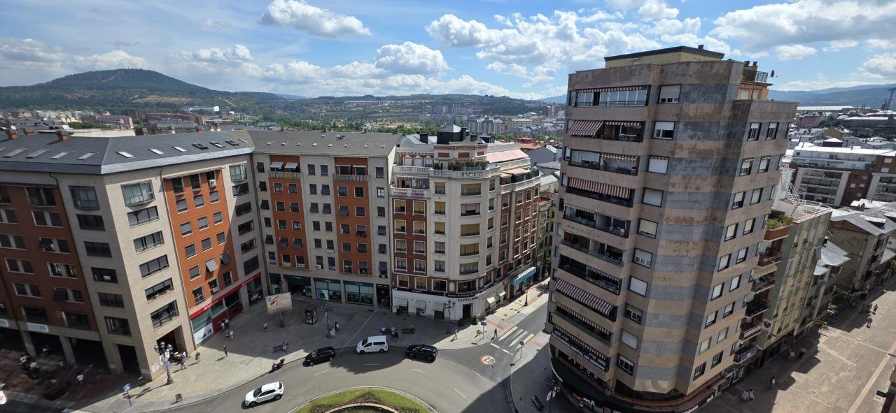 Vista panorámica de edificios en una ciudad con montañas al fondo