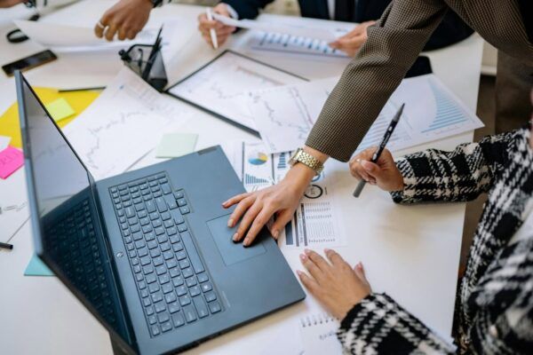 Reunión de trabajo con un ordenador y documentos sobre la mesa