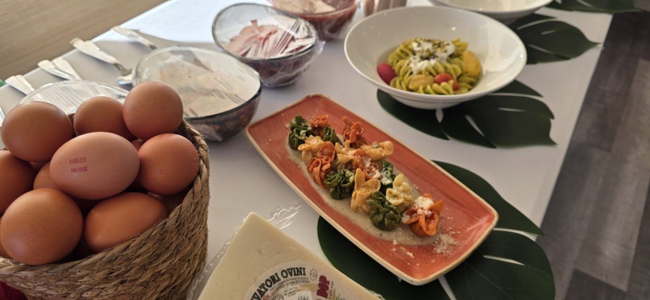 Mesa con ingredientes y platos de pasta en la fiesta de Mama Mia