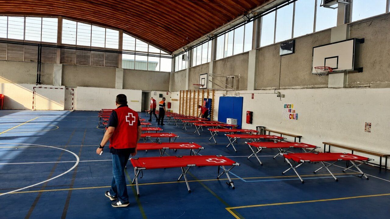 Interior del albergue de Cruz Roja en Toreno con camas desplegadas
