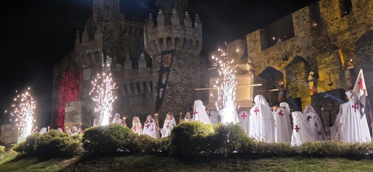 Desfile Templario con participantes vestidos de blanco y cruces rojas