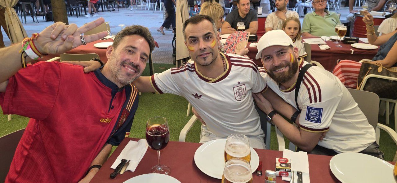 Tres aficionados celebrando en la Plaza Fernando Miranda durante el partido España-Bélgica.