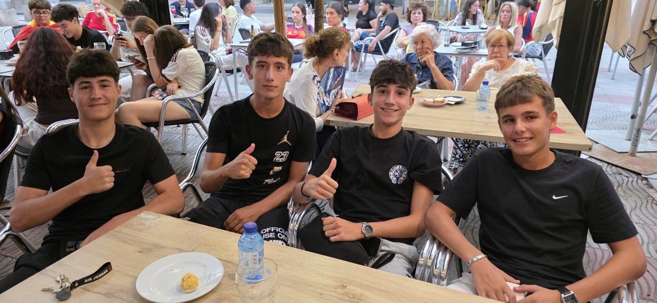 Cuatro jóvenes aficionados animando en la Plaza Fernando Miranda durante el partido España-Bélgica.
