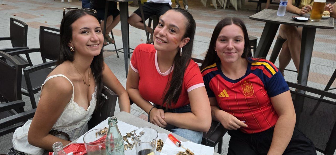 Tres jóvenes aficionados en la Plaza Fernando Miranda durante el partido España-Bélgica.