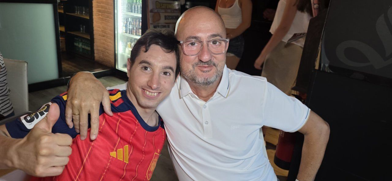 Dos aficionados sonrientes en la Plaza Fernando Miranda durante el partido España-Portugal.