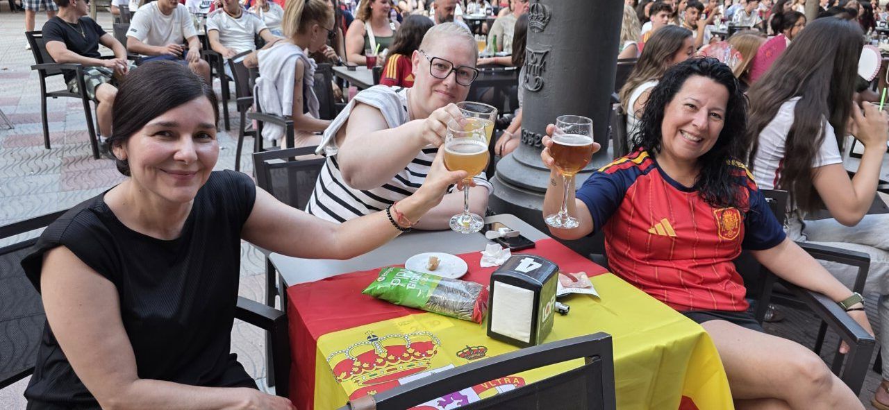 Tres mujeres celebrando en la Plaza Fernando Miranda durante el partido España-Portugal