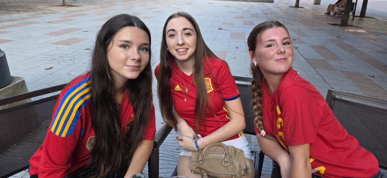 Tres jóvenes aficionados animando a España en la Plaza Fernando Miranda