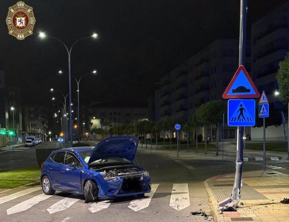 Accidente de tráfico en León con un coche dañado y una farola caída