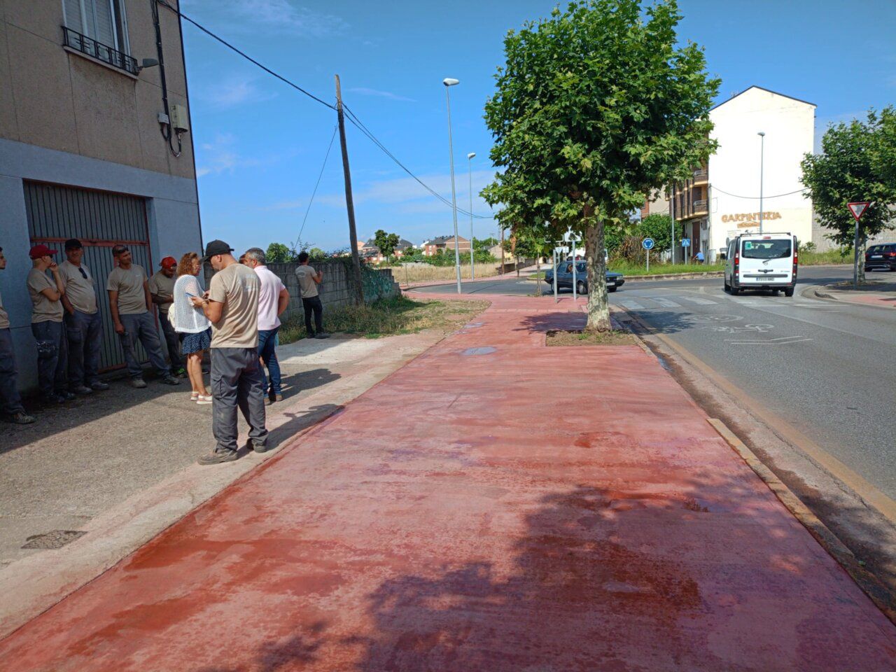 Grupo de trabajadores en la acera recién mejorada en Ponferrada