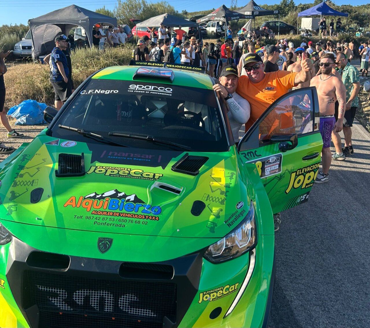 Piloto y aficionado celebrando junto a un coche de carreras en Riego de Ambrós.