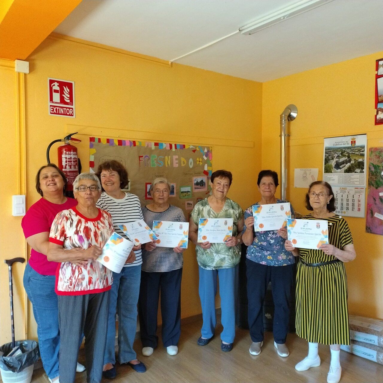 Grupo de mujeres sosteniendo diplomas en un evento comunitario