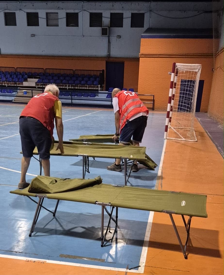 Voluntarios de Cruz Roja preparando camas en un albergue