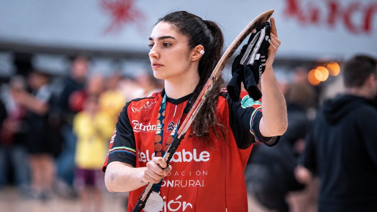 Angy Fernández con su equipo de hockey, sosteniendo un stick y guantes.
