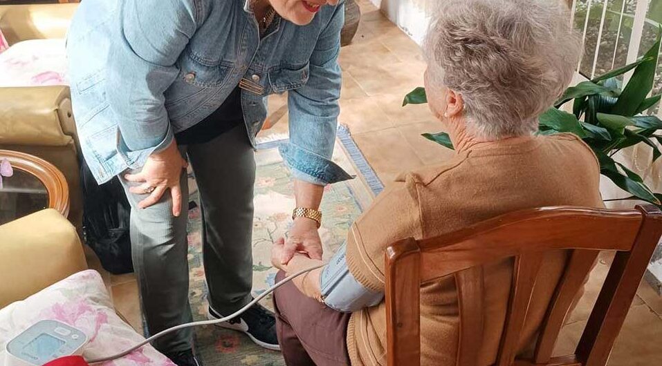 Profesional de salud asistiendo a una persona mayor en su hogar