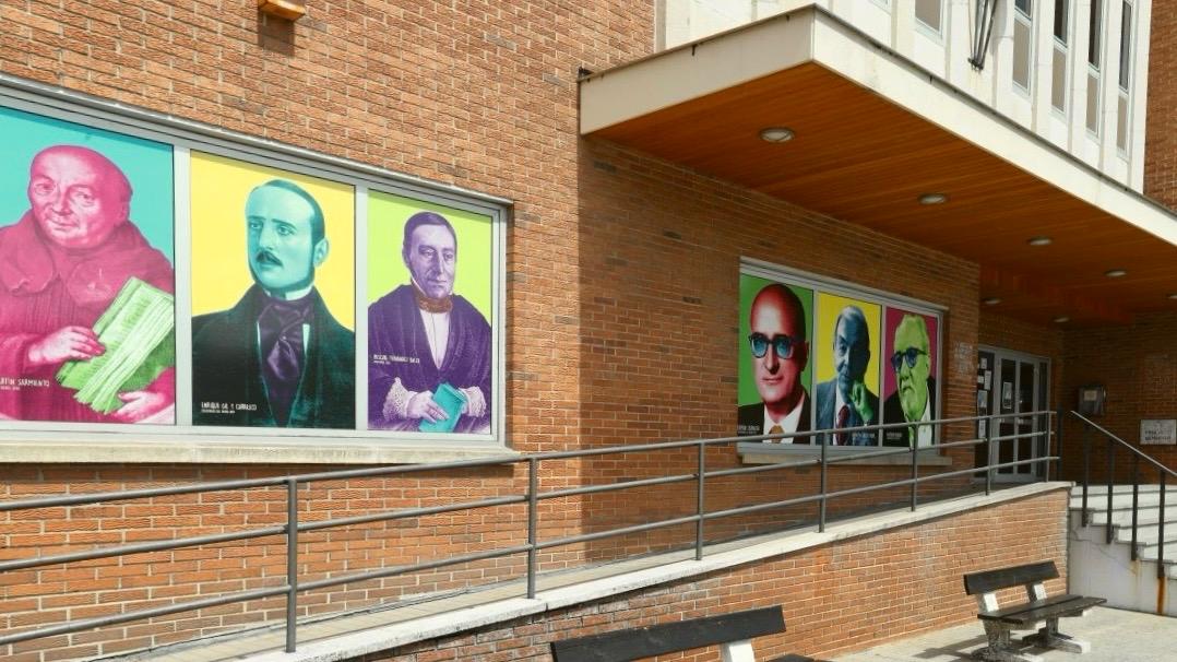Fachada de la Biblioteca Municipal de Ponferrada con retratos coloridos