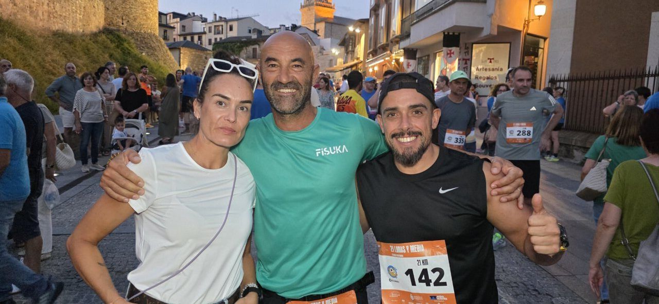Tres corredores sonrientes en la carrera nocturna 21 Lunas y Media en Ponferrada