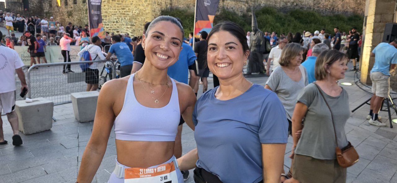 Dos mujeres sonrientes en la carrera nocturna 21 Lunas y Media en Ponferrada.