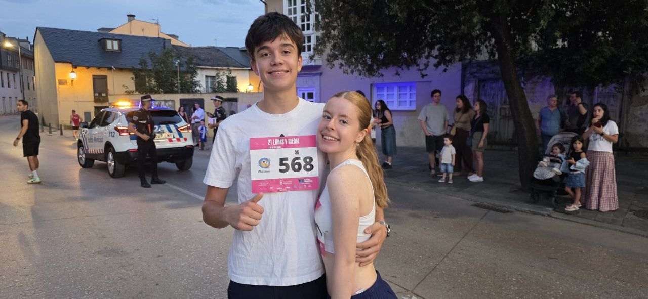 Dos jóvenes sonrientes con dorsal en la carrera nocturna 21 Lunas y Media