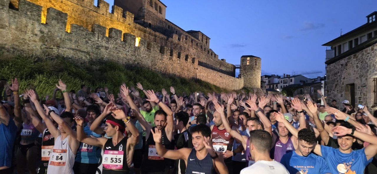 Corredores levantando las manos antes de la carrera nocturna en Ponferrada