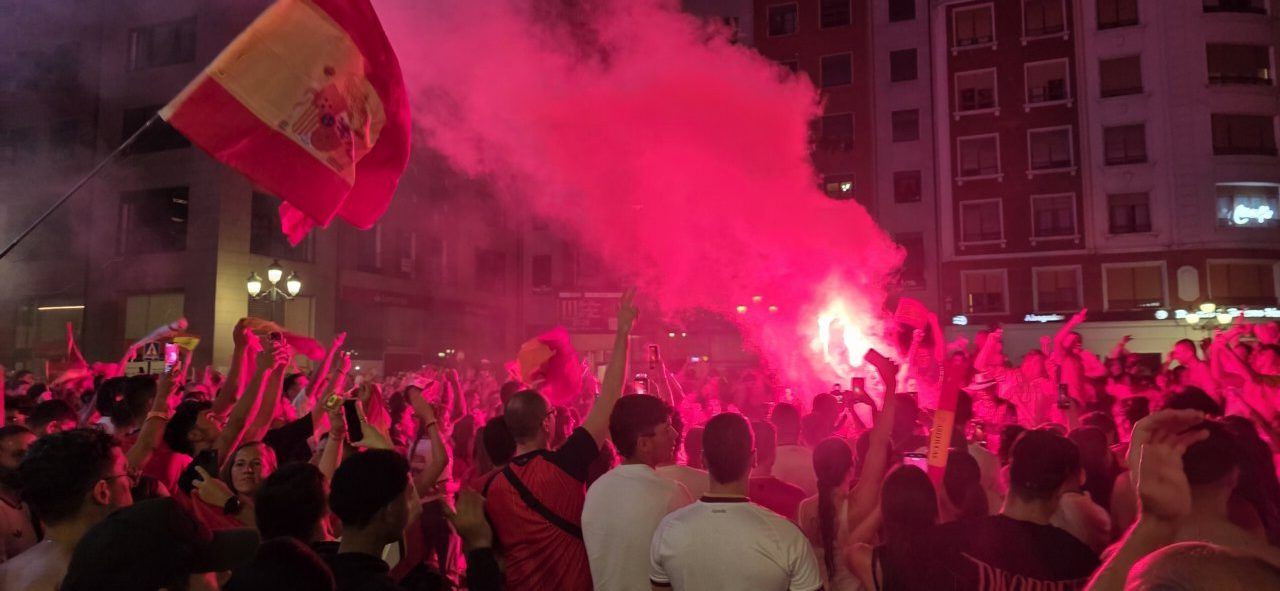 Aficionados celebrando la victoria de España en Ponferrada con banderas y fuegos artificiales.
