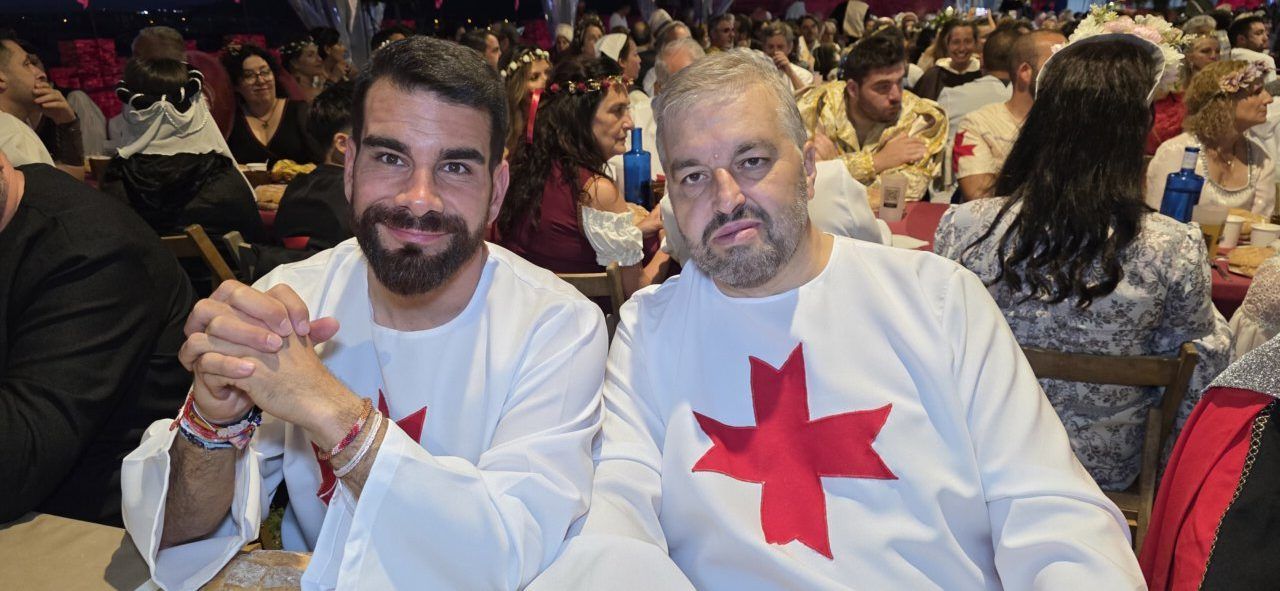 Dos hombres con túnicas blancas y cruces rojas en una cena templaria