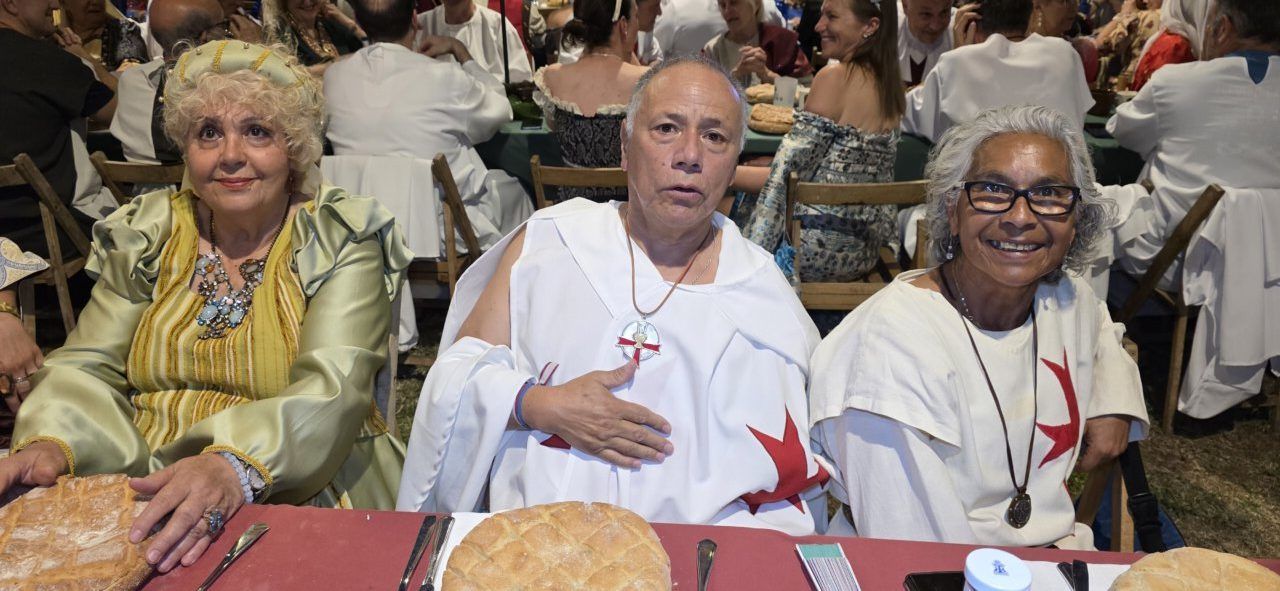 Tres participantes de la Cena Templaria en Ponferrada con vestimenta tradicional.