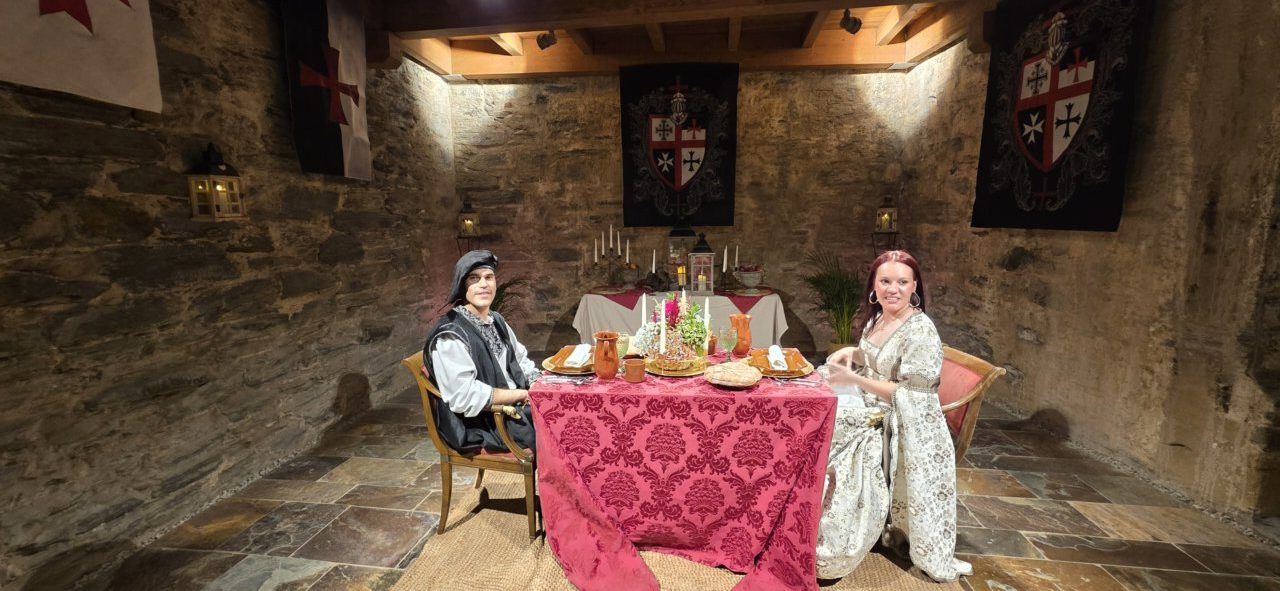 Dos personas sentadas en una mesa decorada para la Cena Templaria