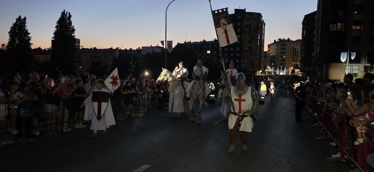 Desfile Templario con caballeros y público en la calle al atardecer