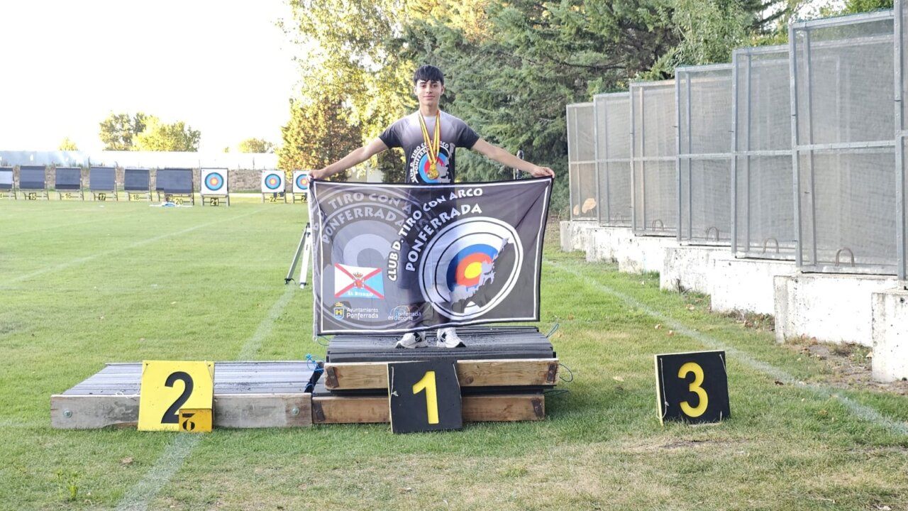 Joven arqueros sosteniendo una bandera en el podio de tiro con arco
