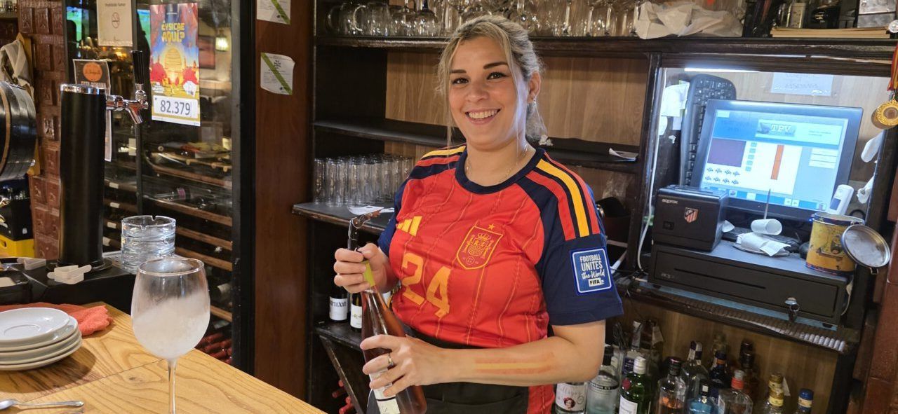 Mujer sonriendo en bar con camiseta de España durante final del Mundial