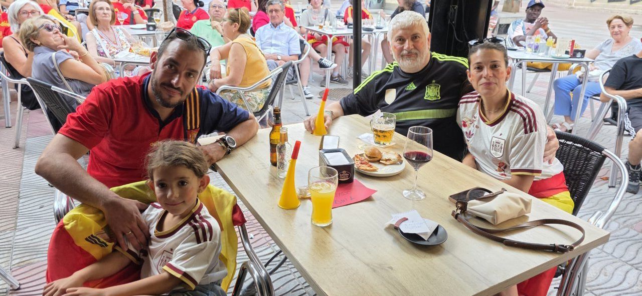 Familia disfrutando del partido España contra Argentina en un bar