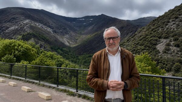Persona en un paisaje montañoso con vegetación y nubes