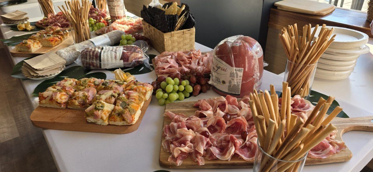 Mesa con variedad de pizzas y embutidos en la fiesta de aniversario.