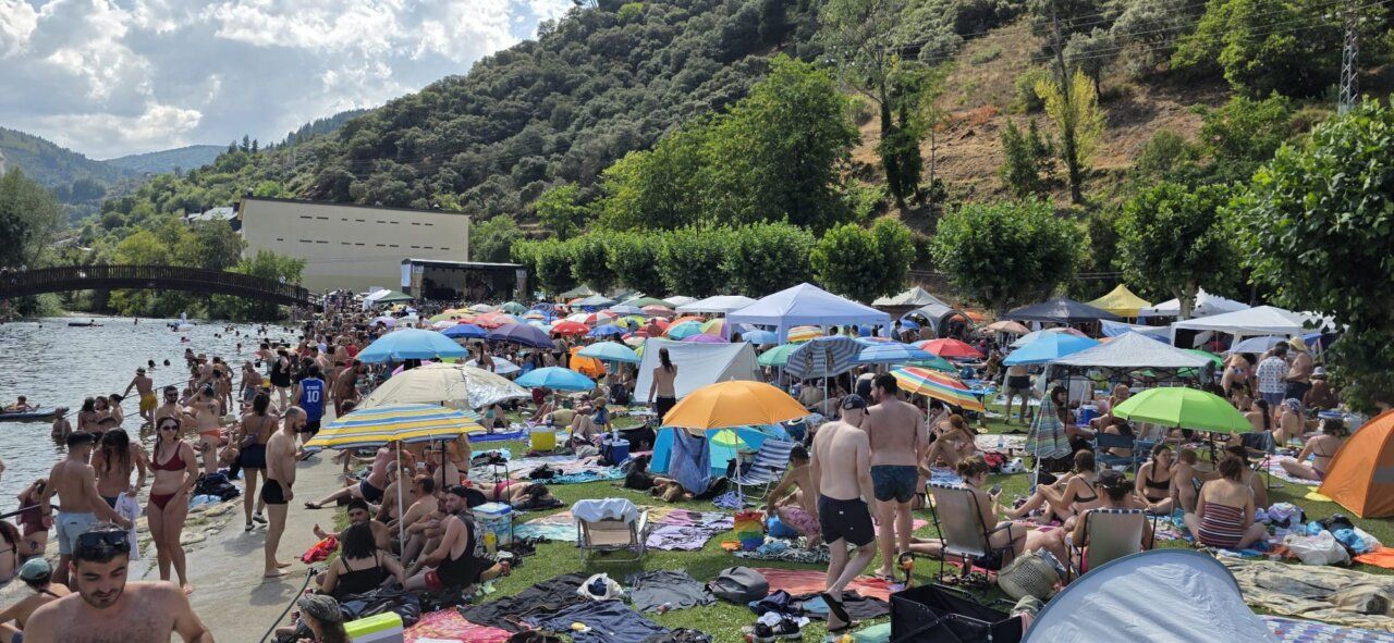 Multitud de personas disfrutando en un festival de verano junto al río