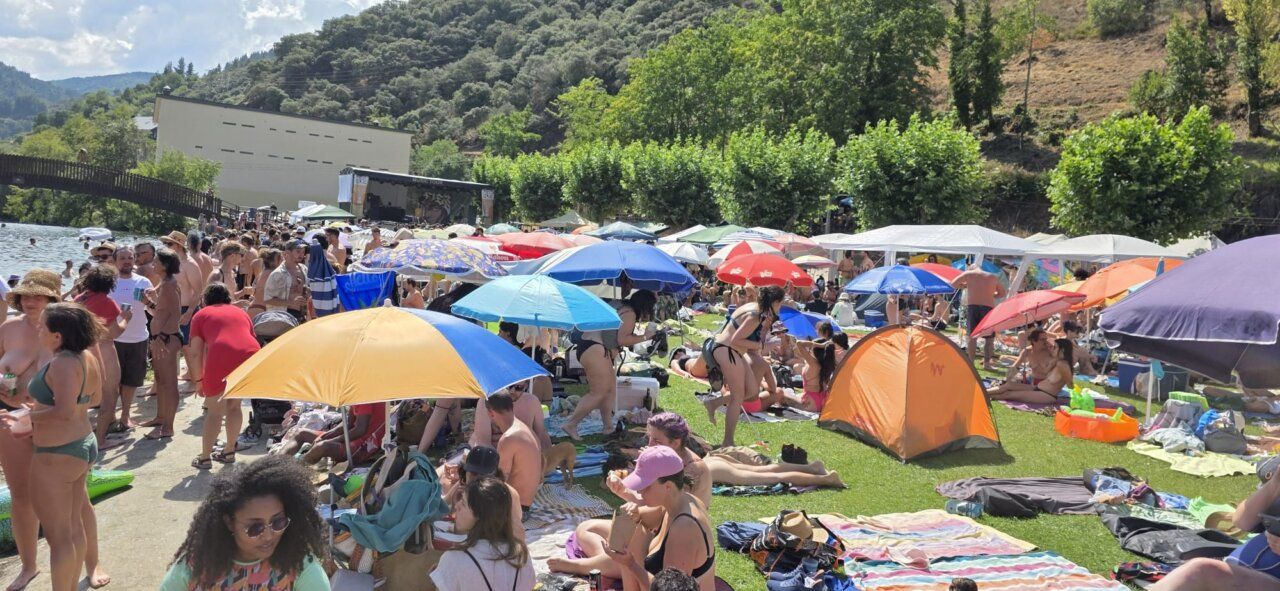Multitud de personas disfrutando en la playa con sombrillas y tiendas