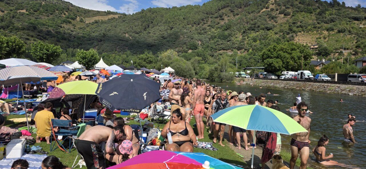 Multitud de personas disfrutando en un evento de verano junto al río